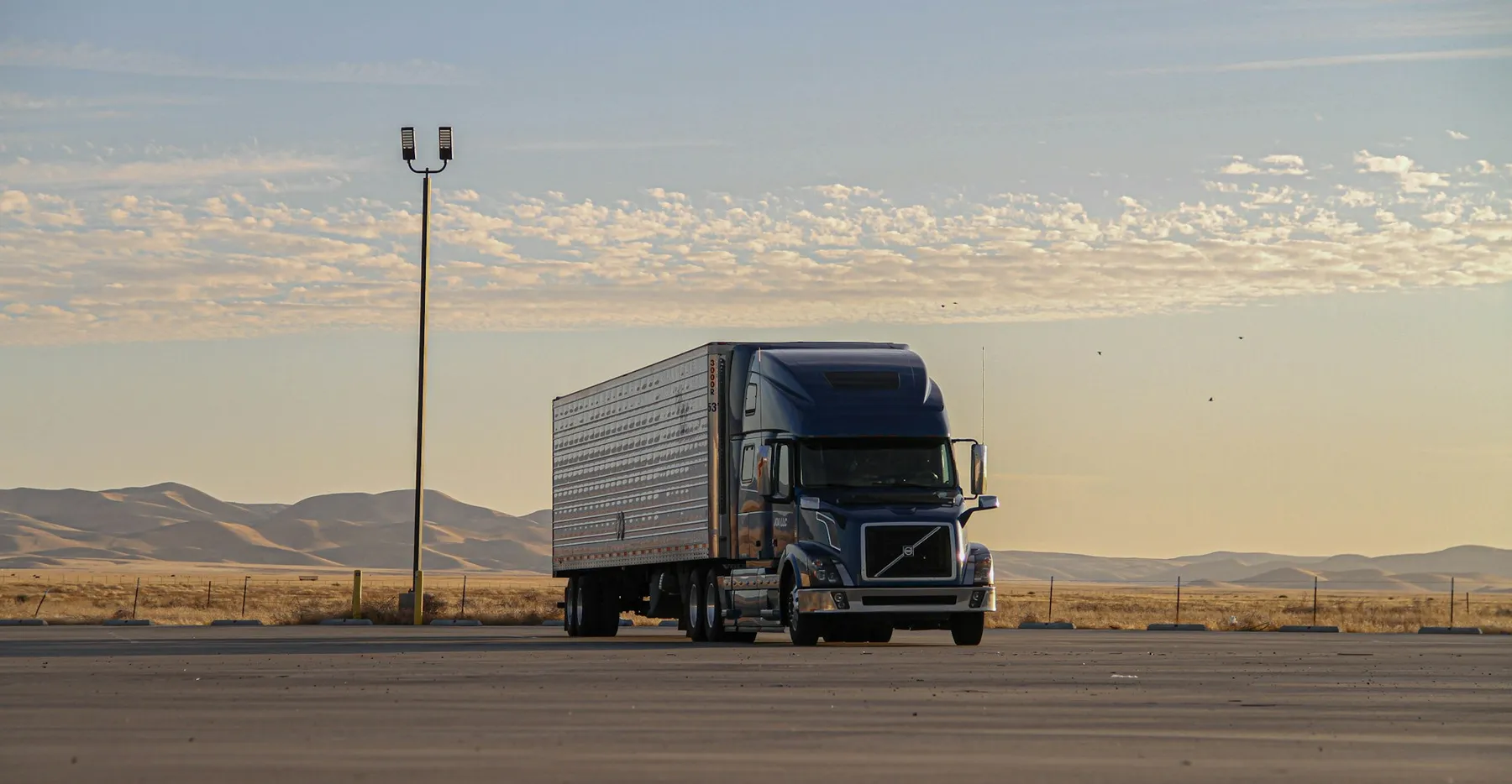 Articulated truck and trailer on an open road at first light